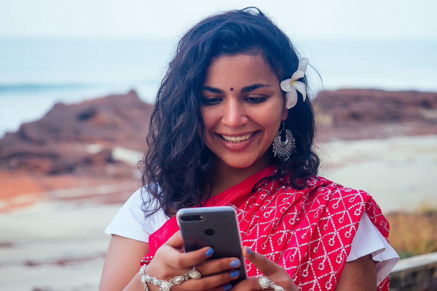 Villager listening to online radio on a mobile phone in a remote area